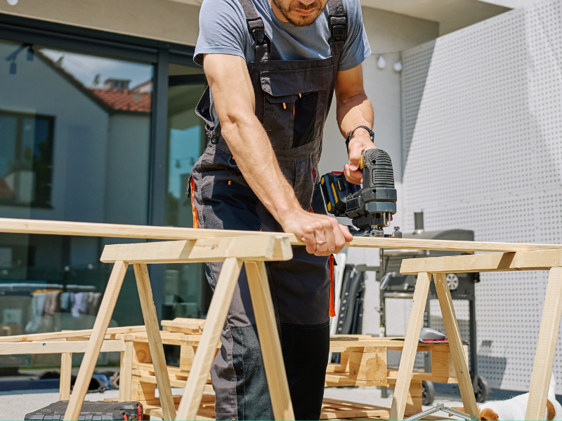 Timmerman aan het werk met houten balken bij NJ Bouw & Techniek